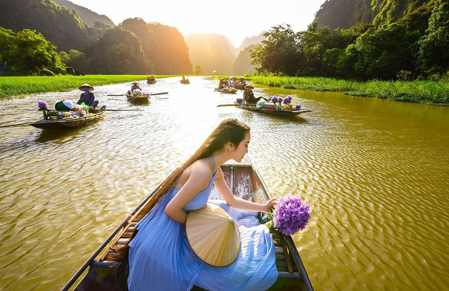 The most beautiful thing to do during the rice season in Tam Coc is a rowboat ride along the Ngo Dong River. 